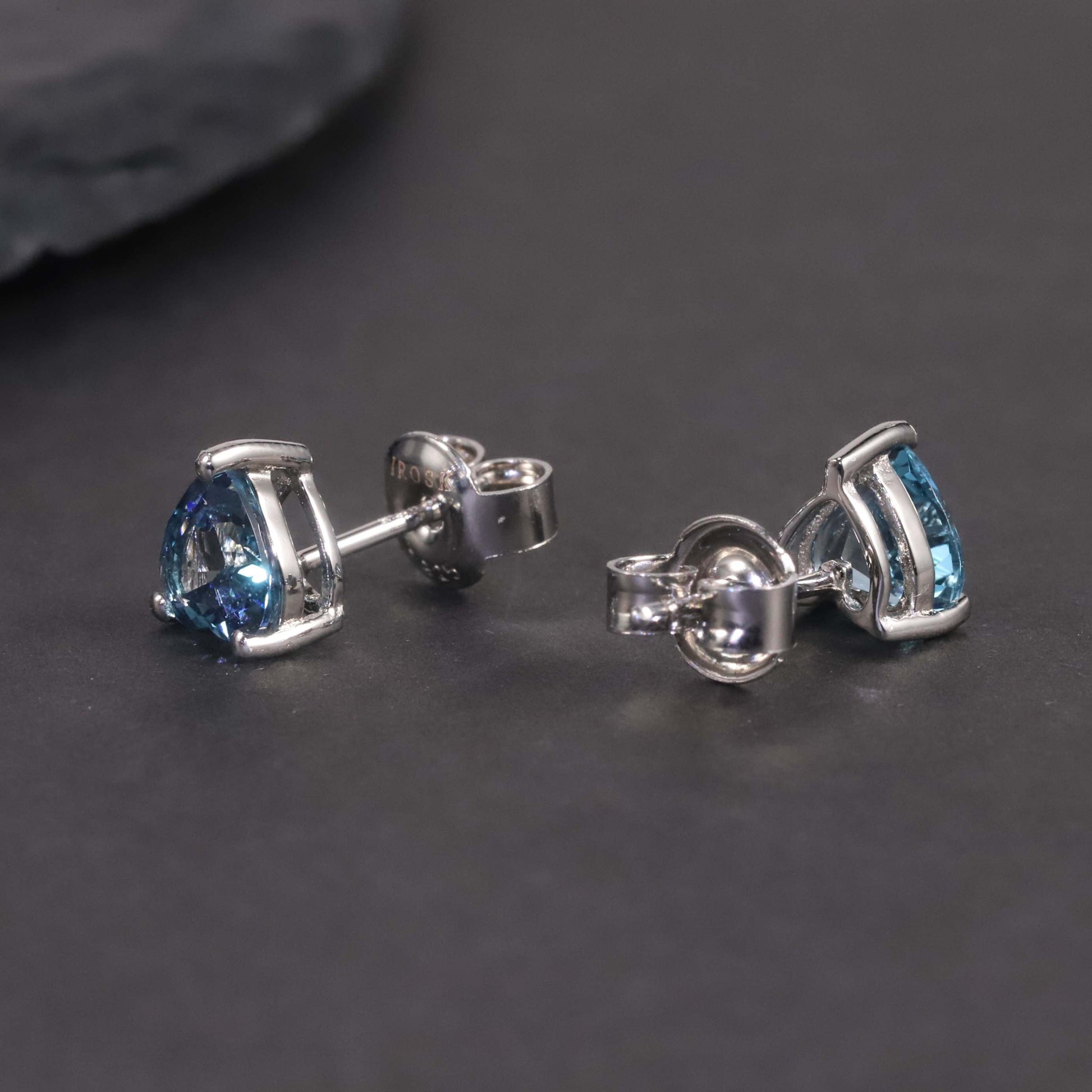 another view of lb topaz stud earrings on dark background