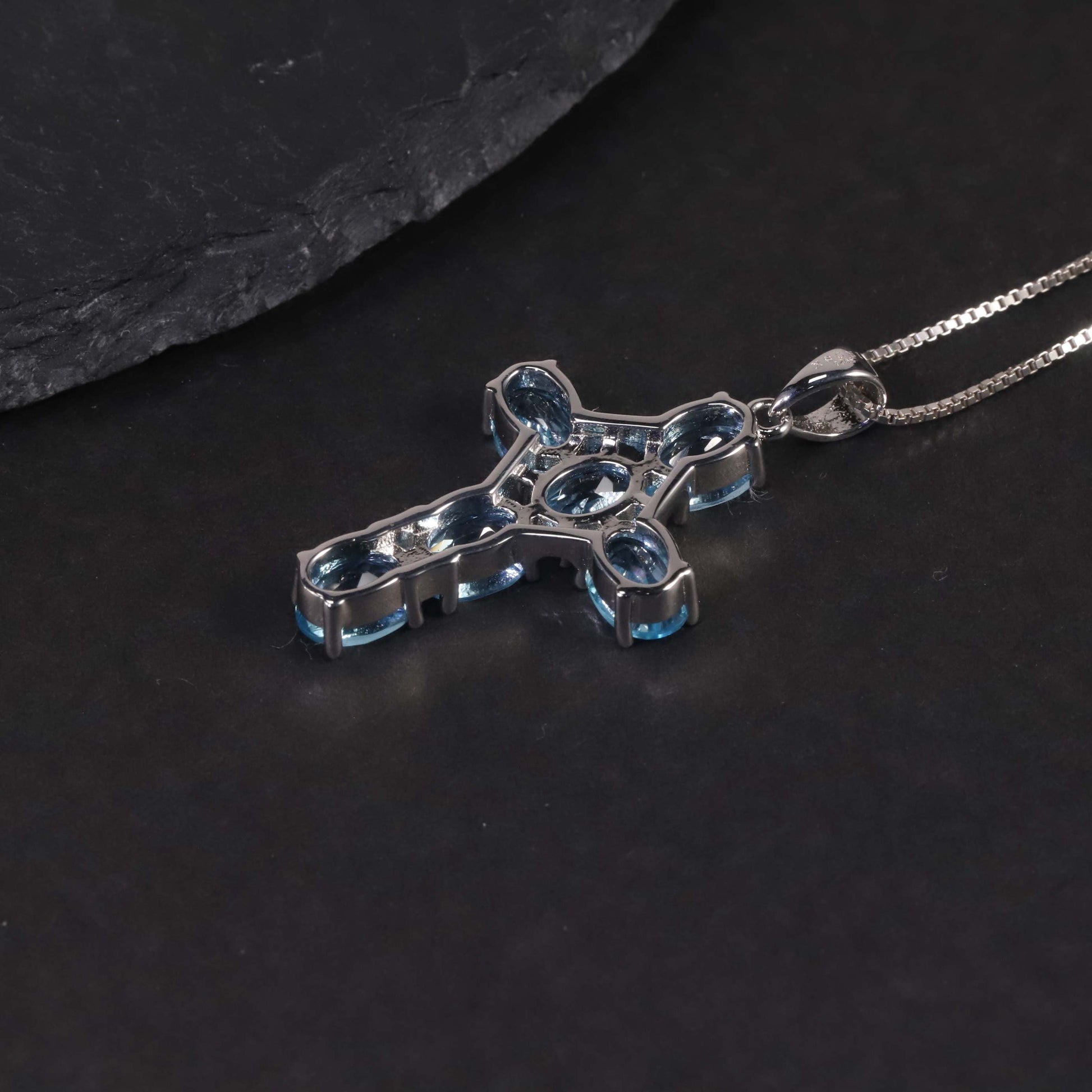 backside of cross pendant with dark background