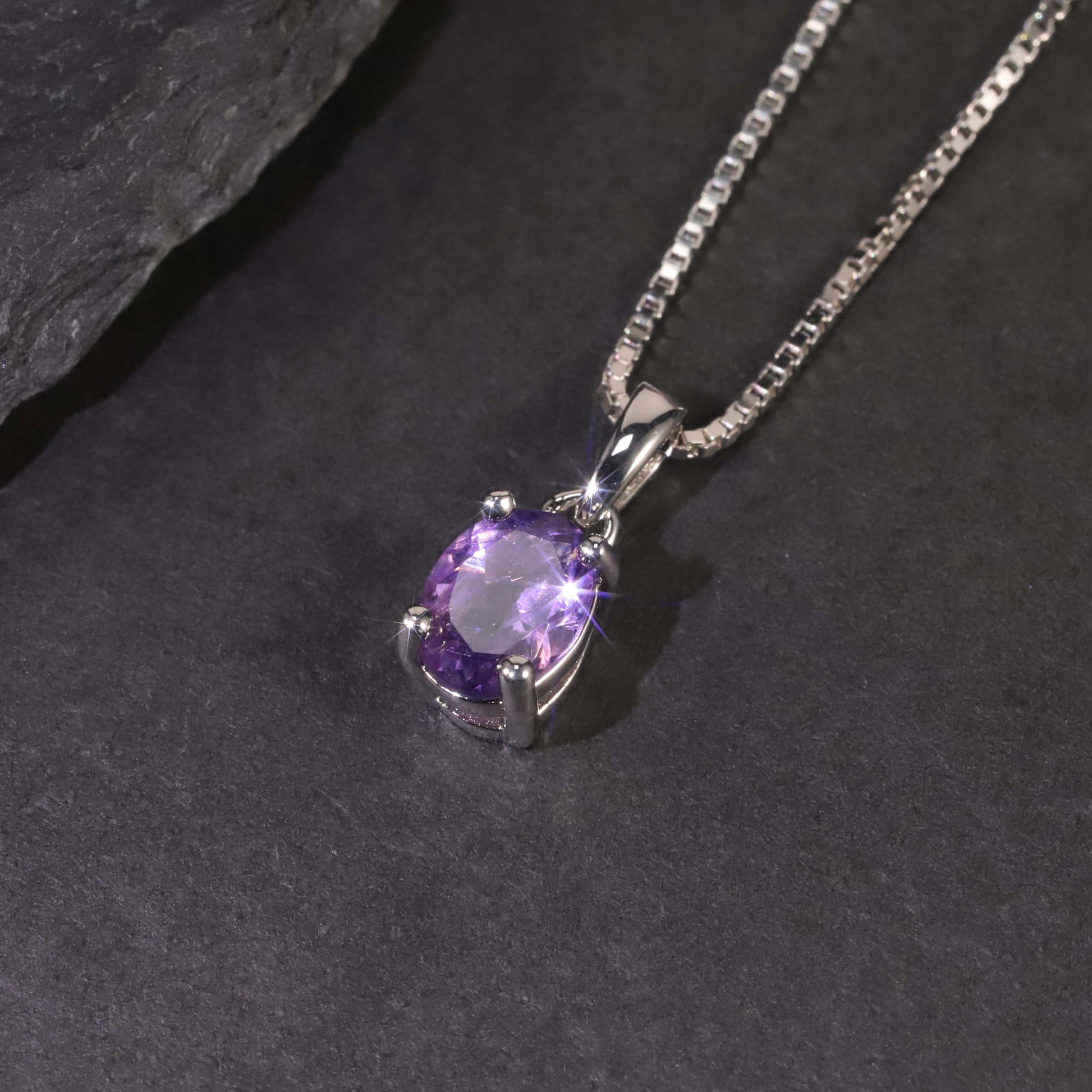 top view of amethyst oval pendant on dark background