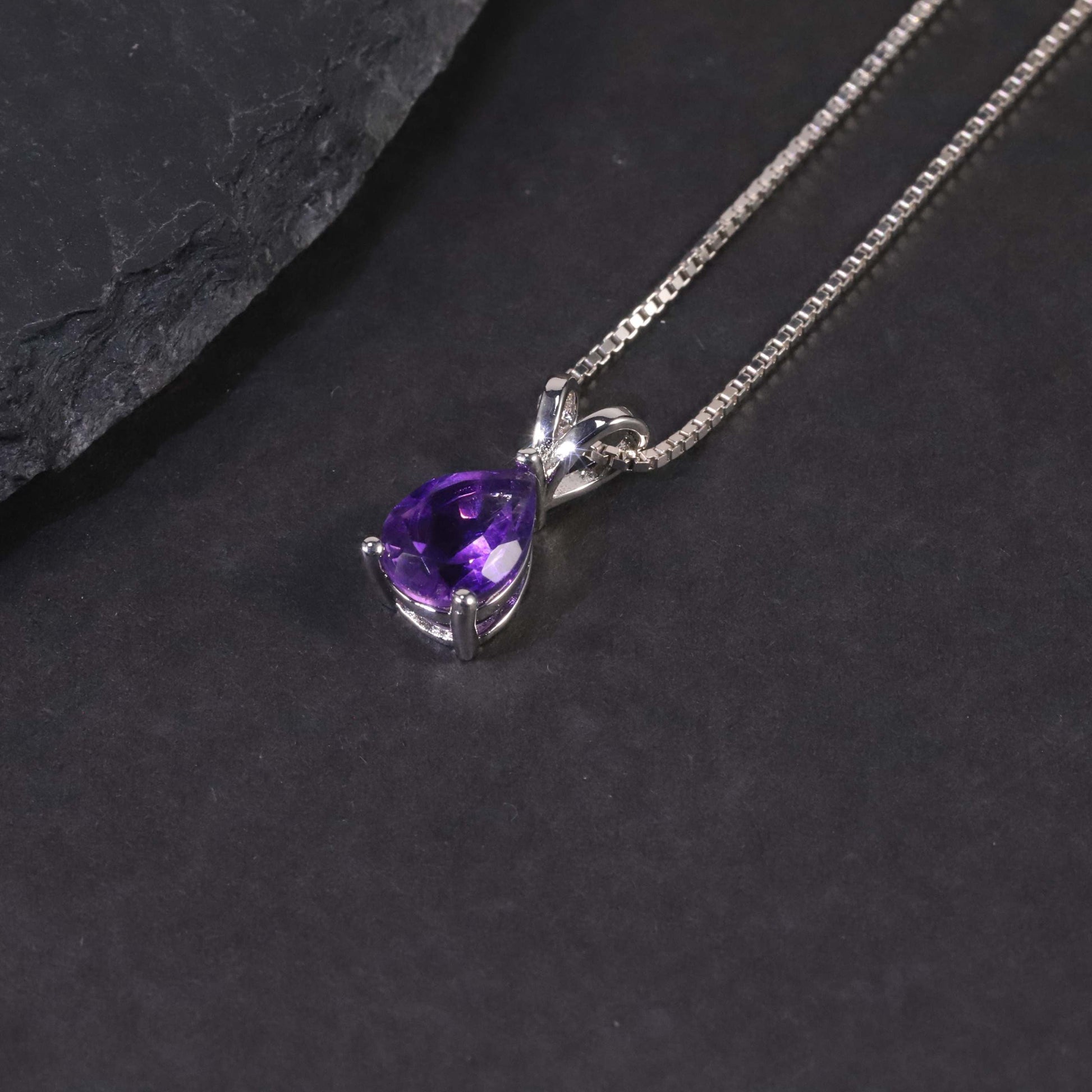 Side view of the Pear Amethyst Pendant against a dark background, highlighting its exquisite craftsmanship and intricate details.