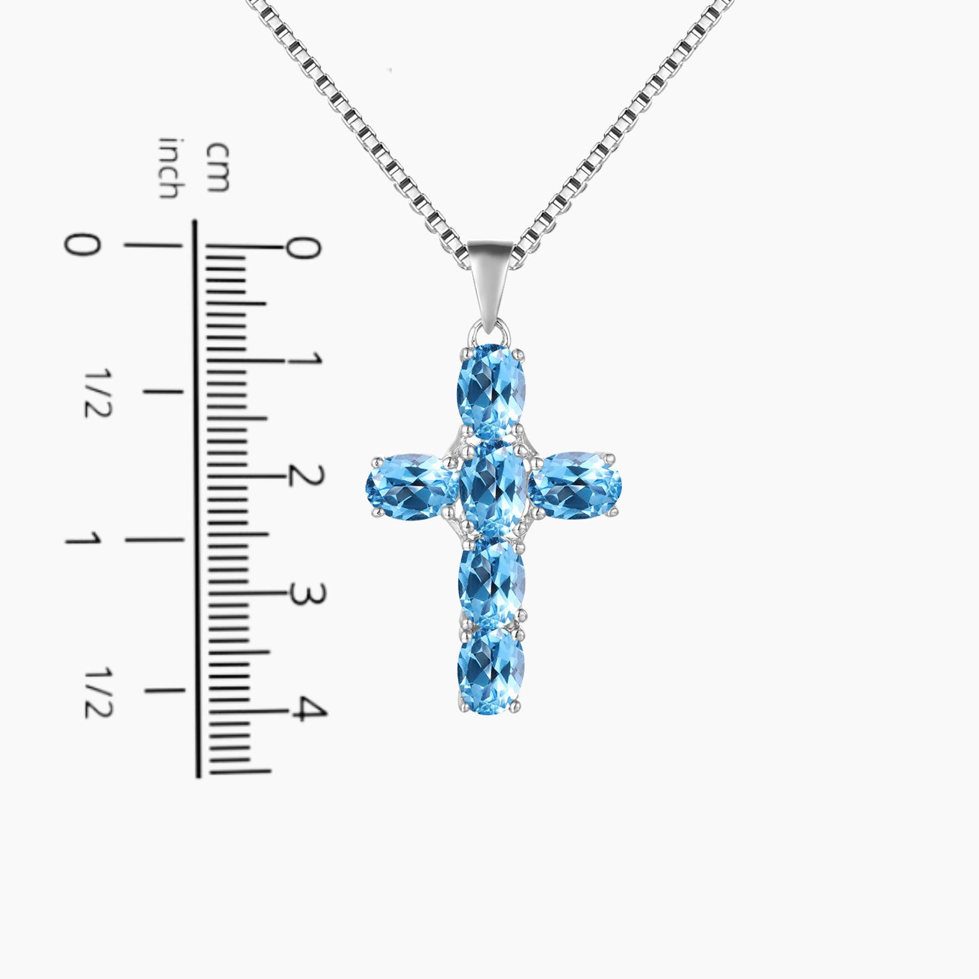 topaz cross pendant next to a scale